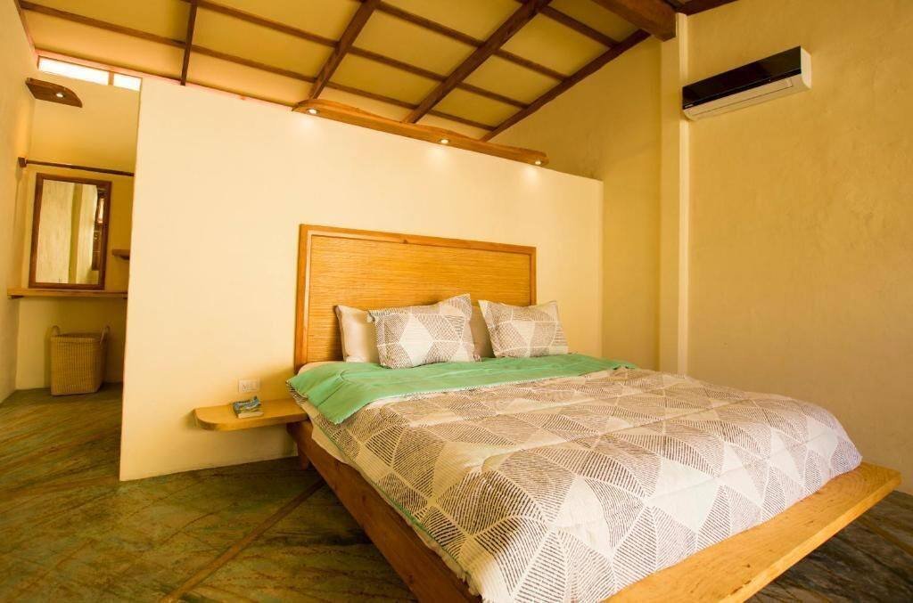Galería Suites San Pancho: suite with a wooden bed, white walls and a beamed ceiling